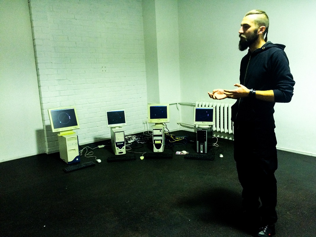 Kuratorius Jurijus Dobriakovas veda ekskursiją. Fone - M. Gapševičiaus kūrinys